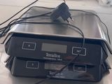 two electronic devices sitting on top of a metal table
