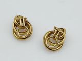 a pair of gold toned earrings with a knot