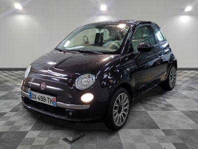 la petite voiture noire est garée sur un carrelage à carreaux