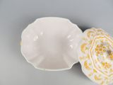 an image of a white bowl with a lid and a yellow flower design