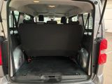 the back end of a silver van with its trunk open