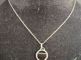 collier plaqué argent avec un pendentif en pierre noire, présenté autour du cou d'un mannequin