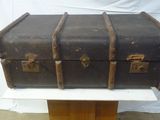 une vieille valise posée sur un support en bois