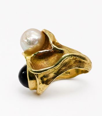 une image représentant une bague en or ornée d'une perle et d'un onyx noir