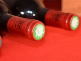several bottles of wine are lined up on a red surface