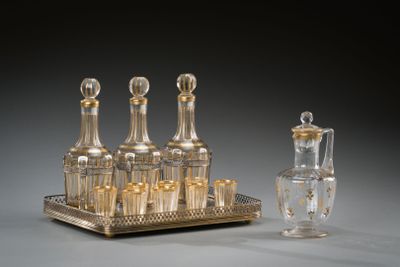 un plateau en argent avec quatre bouteilles et une carafe en verre