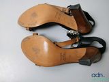 pair of women ' s black leather sandals with metal accents on them