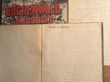 un vieux livre posé sur une table en bois, à côté d'une feuille de papier