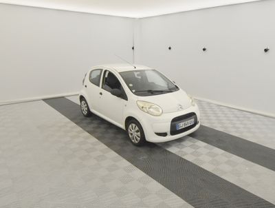 une petite voiture blanche garée dans une pièce blanche