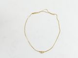 un bracelet à chaîne en or avec une breloque en forme de cœur sur fond blanc