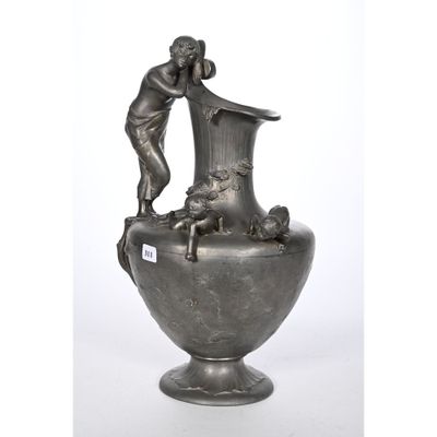 un vase en argent surmonté d'une statuette