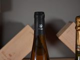 two bottles of wine sitting on a table next to each other