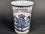 a blue and white cup with a picture of a man riding a horse