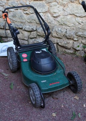two lawn mowers sitting next to each other on the ground