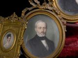 deux portraits encadrés représentant un homme et une femme assis sur une chaise