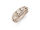 un gros plan d'une bague sertie de trois diamants sur fond blanc