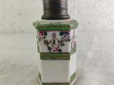 a white and green vase with flowers on it