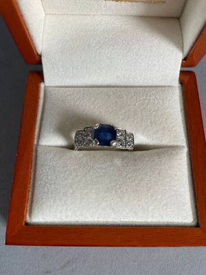a ring in a box with a blue stone in it