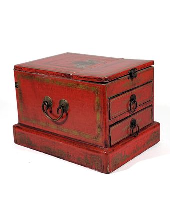 a small red box with three drawers on it