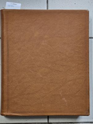 an old brown book sitting on top of a tiled floor