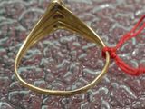 a gold ring with a red string attached to it