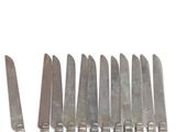 a lot of knives that are lined up on a table