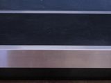 stainless steel coffee table with a black glass top on a wooden floor