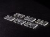 six pieces of clear plastic sitting on top of a black surface