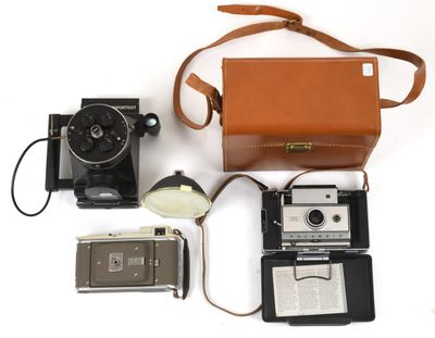a camera, a camera case, a cell phone, and a camera on a white surface