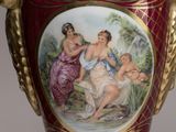 a red vase with a painting on the side of it