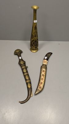 deux couteaux et un vase posés sur une table