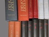several books are stacked on top of each other on a shelf