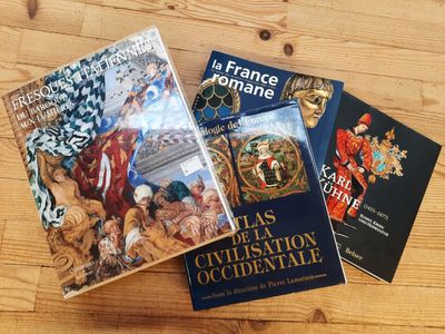 three books on a wooden table with a wooden table in the background