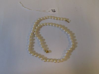 un collier de perles blanches avec un fermoir doré