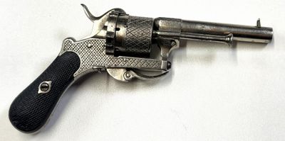 un vieux revolver argenté avec une crosse noire sur un fond blanc