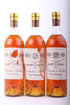 trois bouteilles de vin posées les unes à côté des autres sur une surface blanche
