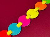 brightly colored paper chain on a red surface with a red background