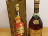 two bottles of brandy sitting next to each other on a wooden table