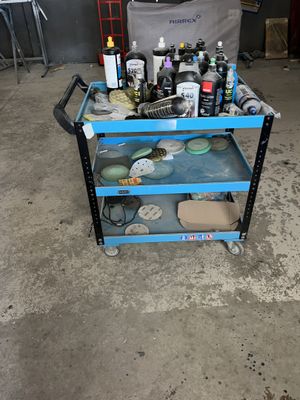 a blue cart with various items on it in a garage