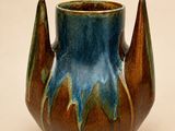 un vase bleu et marron posé sur une table