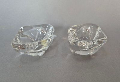une paire de cendriers en verre transparent posés sur une table