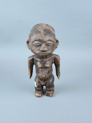 une vieille figurine en bois représentant un homme aux yeux fermés