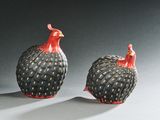 deux oiseaux noirs et rouges, assis l'un à côté de l'autre sur une table