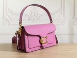 the pink purse is sitting on the table near the wall