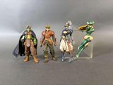 trois figurines représentant différents personnages sont disposées sur une surface grise