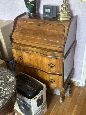 une petite table sur laquelle est posée une lampe, à côté d'une commode