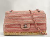 sac à main rose et beige avec une bandoulière en chaîne, sur fond blanc