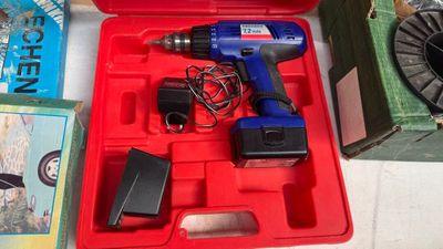 une boîte rouge contenant une perceuse et d'autres outils