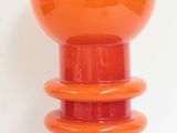 an orange lamp that is on top of a table
