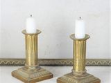 paire de bougeoirs anciens en laiton posés sur un plateau de table en marbre